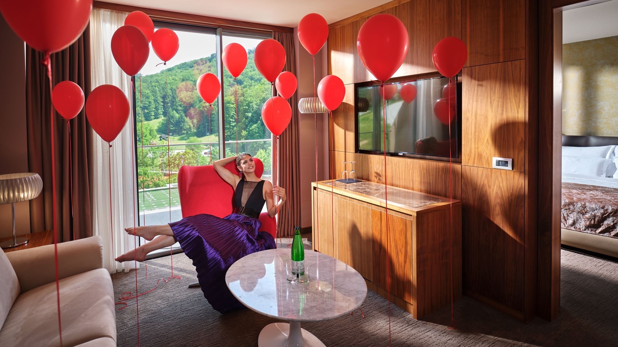 ženska v sobi z rdečimi baloni